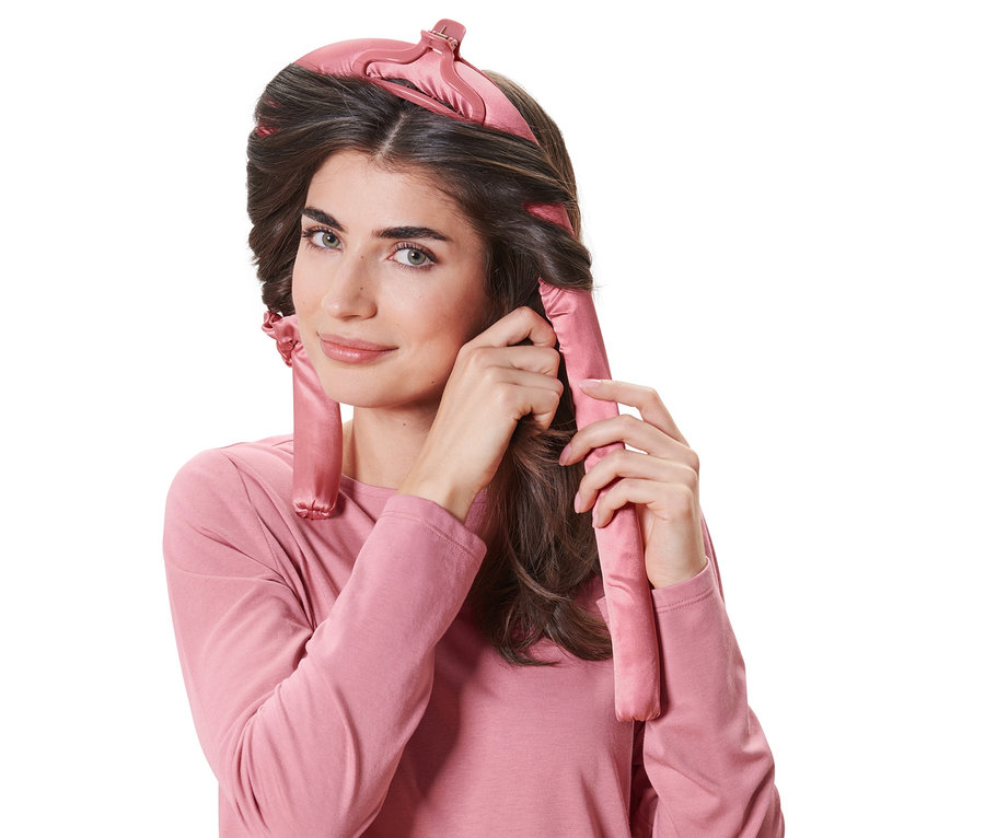 Frau wickelt ihr Haar mit hitzefreien Lockenwicklern.