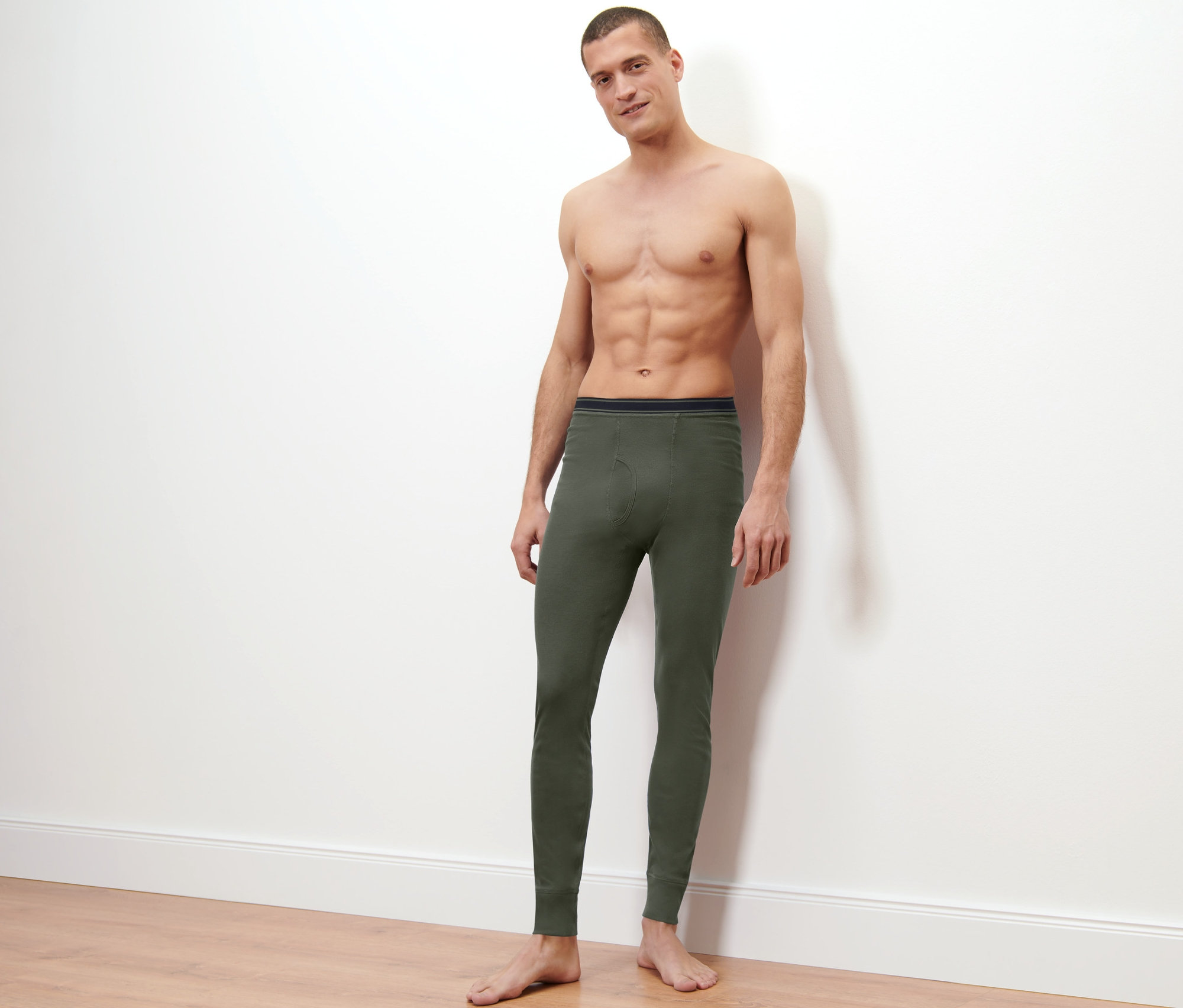 Mann posiert vor hellem Hintergrund und trägt 2 Thermo-Funktionsunterhosen.