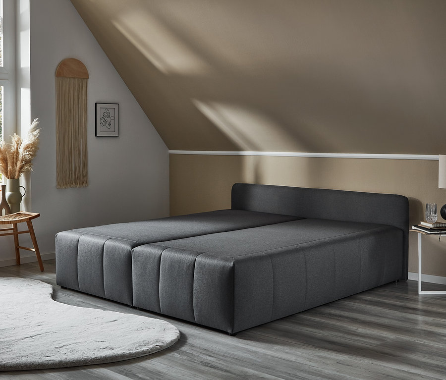 Graues DOMO collection Boxspringbett 180 x 200 cm inklusive Topper im Raum.