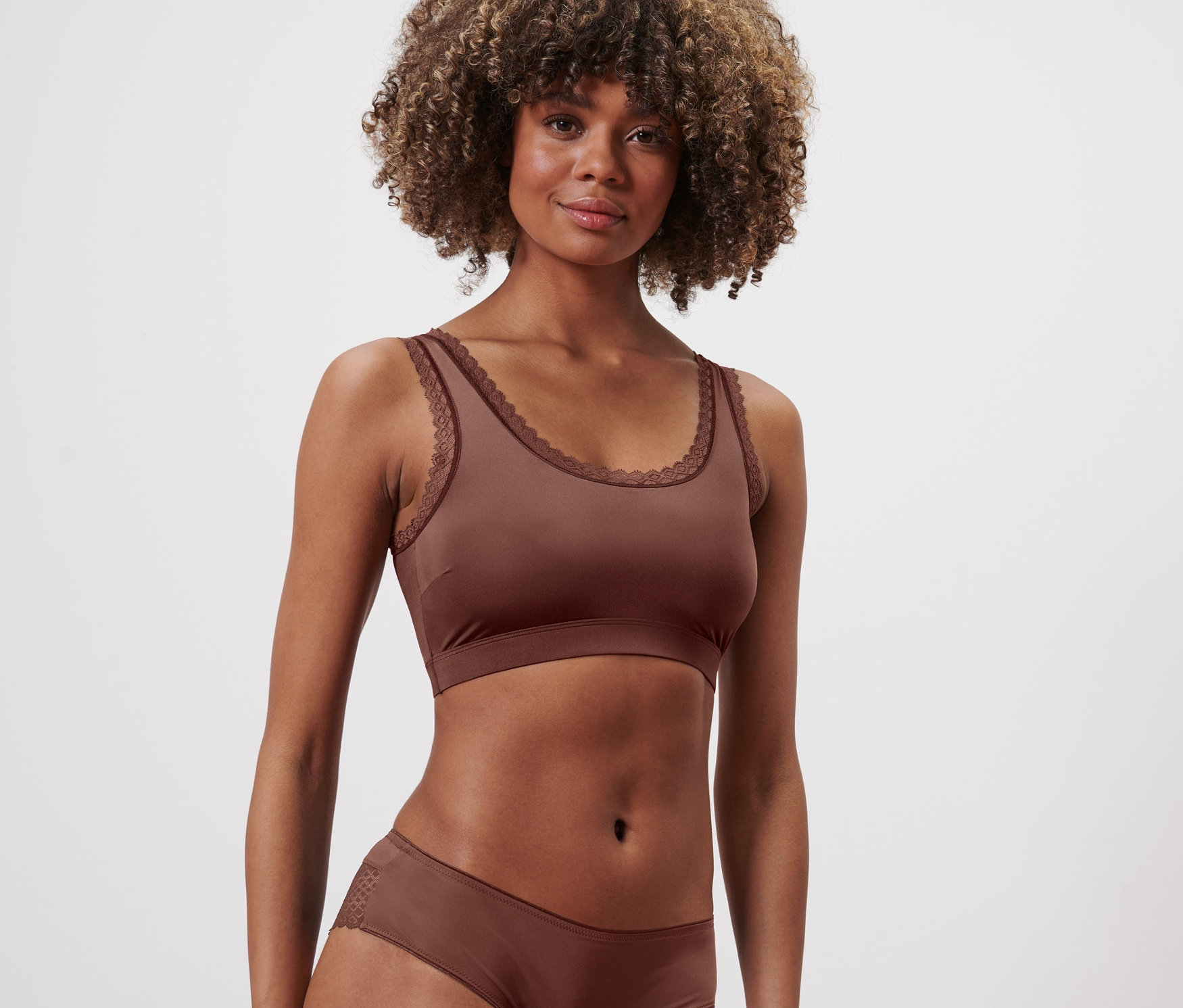 Frau trägt ein kastanienfarbenes Bustier und Unterwäsche.