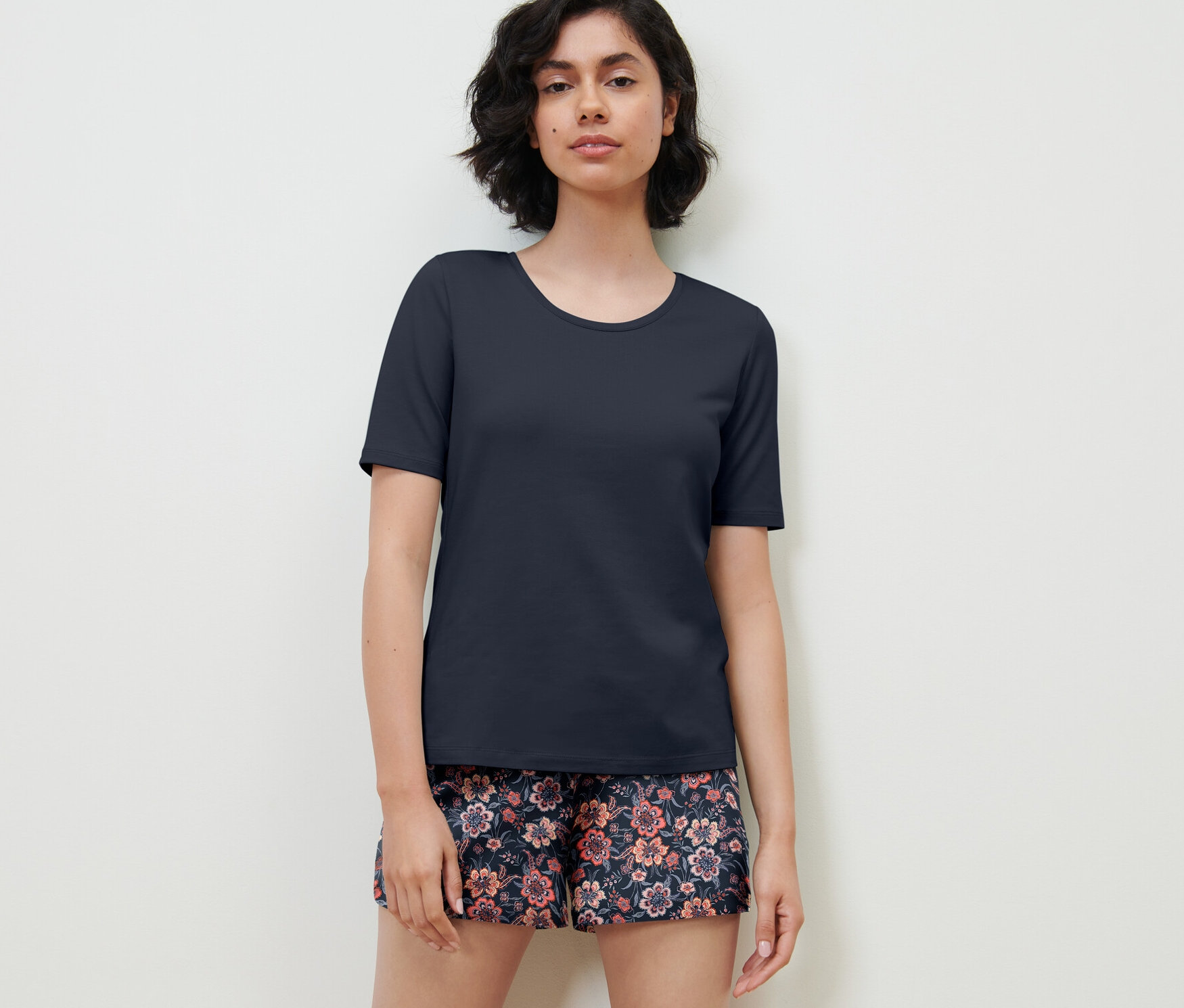 Frau trägt dunkelblauen Shorty-Pyjama.