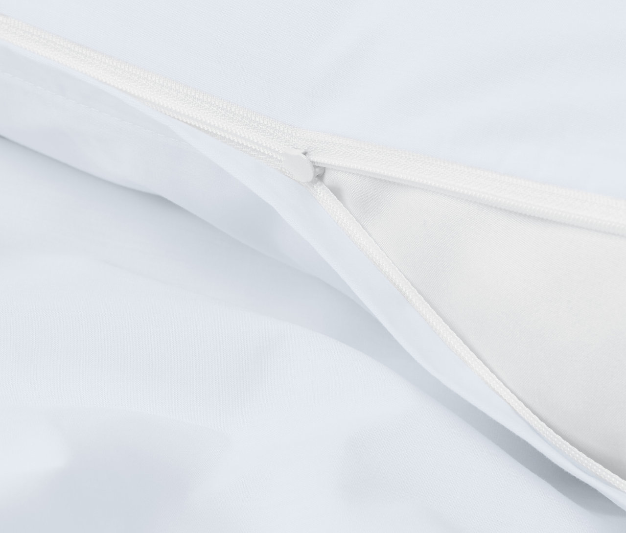 Detailaufnahme eines weißen Bettbezugs mit Reißverschluss.