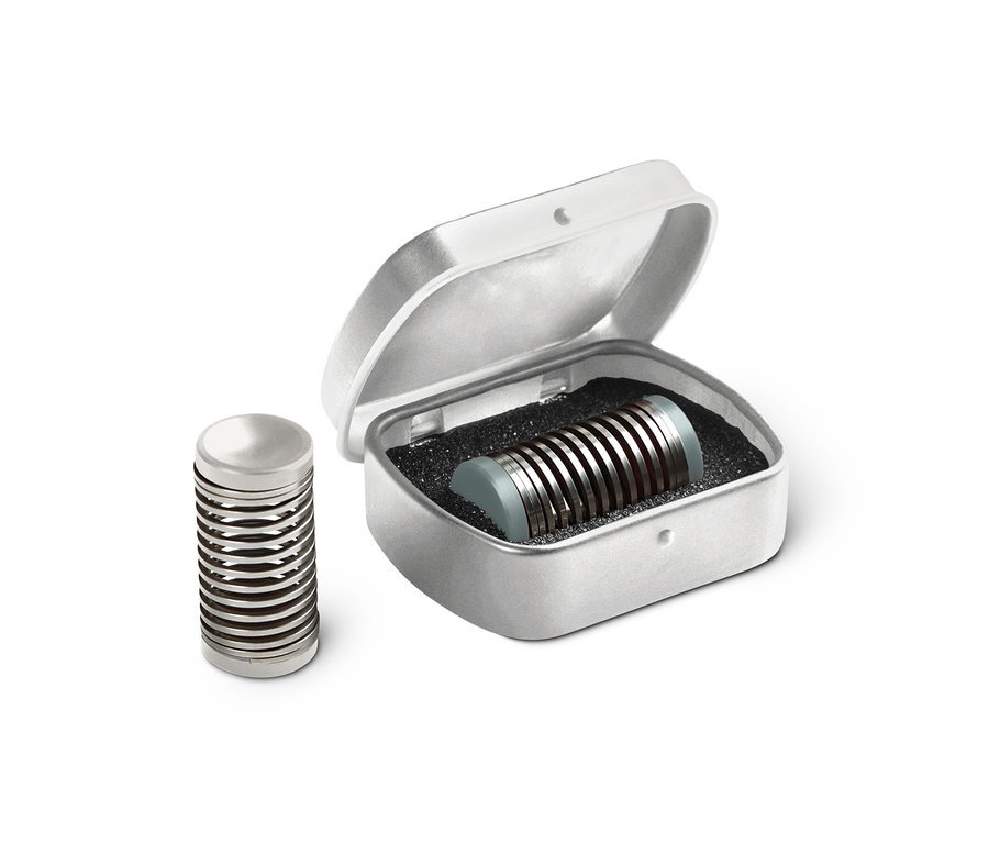 Zwei Mini-Gesichtsepilierer, einer steht neben einer offenen silbernen Schachtel, der andere ist darin.