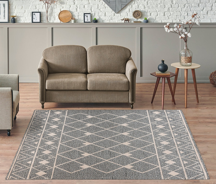 Wohnzimmer mit beigem Sofa, Sessel und grauem Kayoom Rhombus 325 Kurzflorteppich mit geometrischem Muster.
