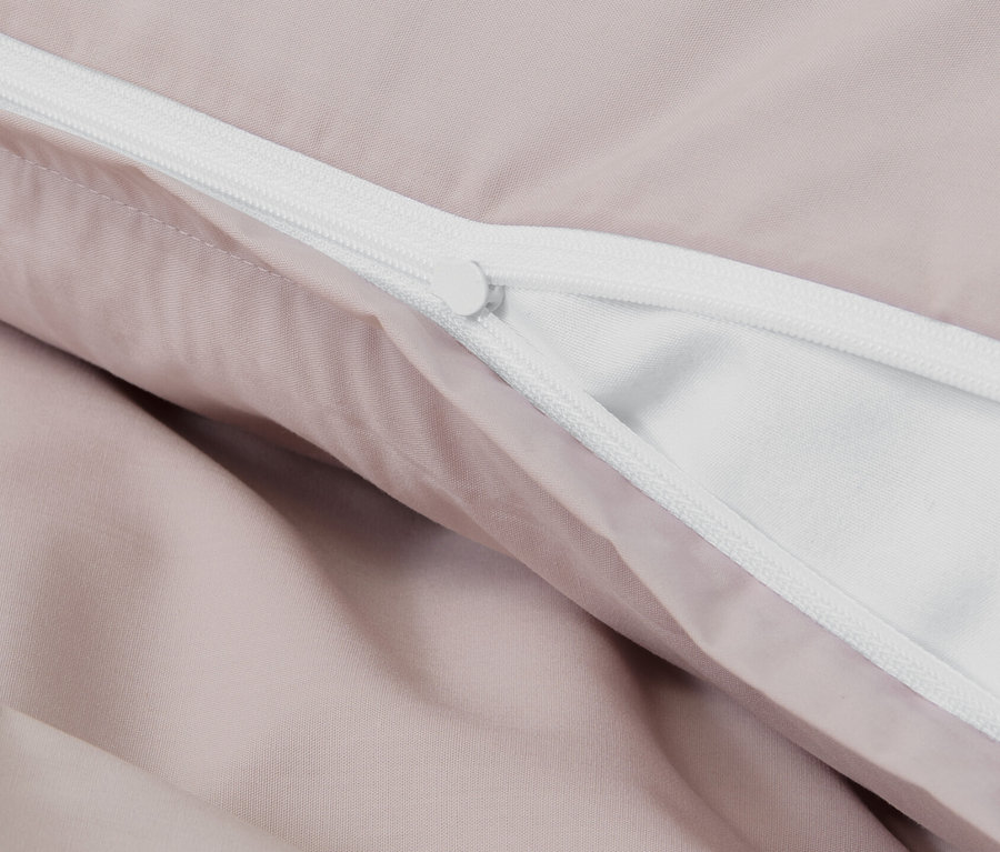 Detailansicht von rosafarbener Perkal-Bettwäsche mit Reißverschluss.