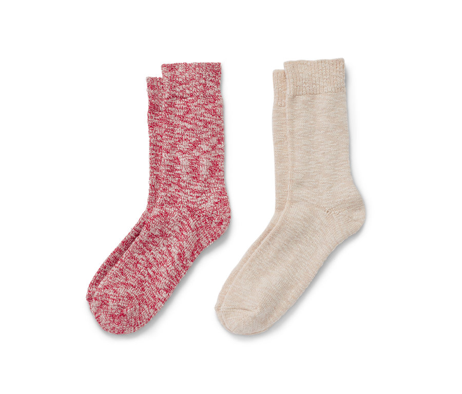 Zwei Paar Stricksocken, ein Paar ist rot-weiß und das andere beige.