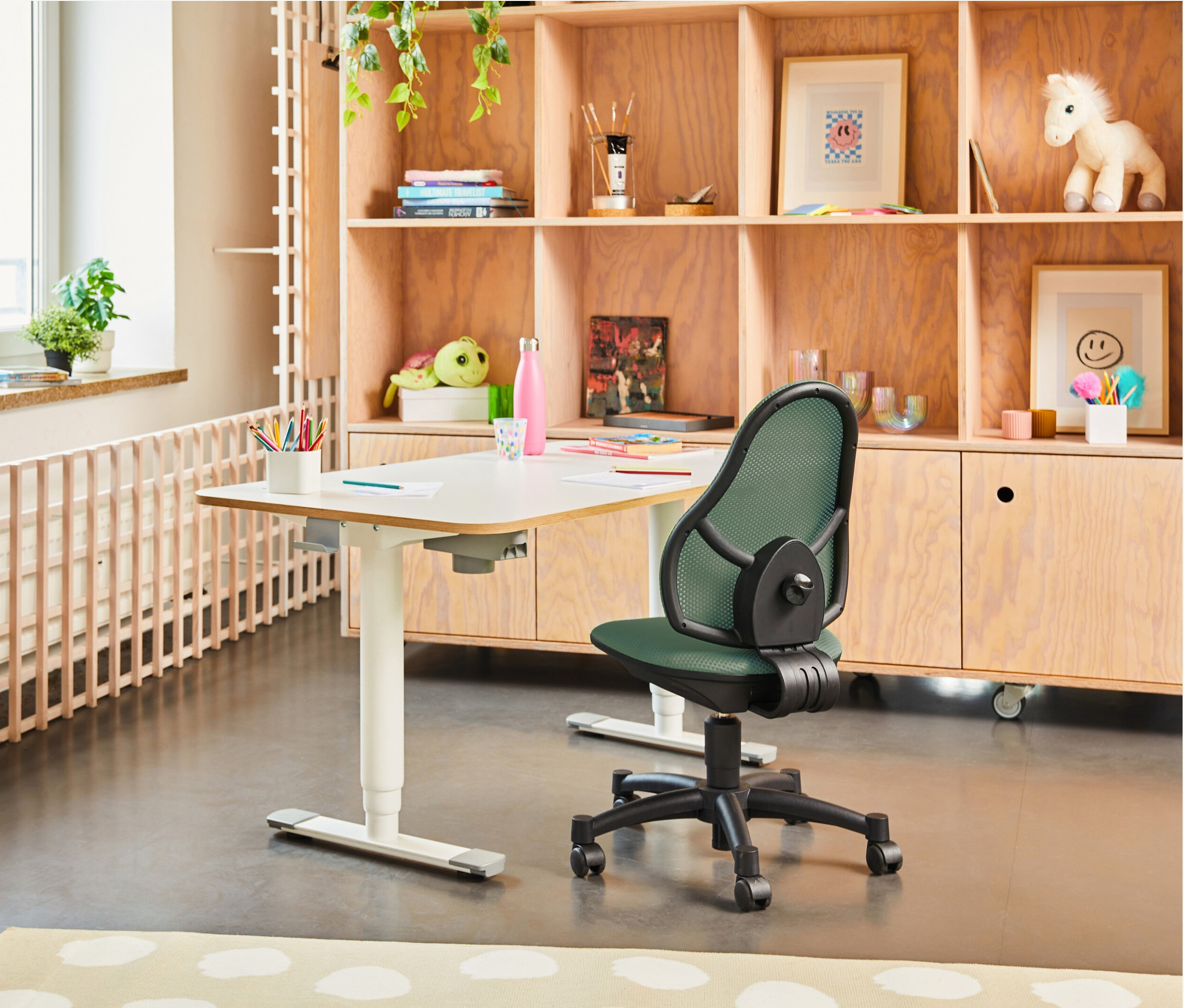 Weißer Schreibtisch mit Büromaterial und mintgrüner Topstar Stuhl »Open Art Junior« im Raum.
