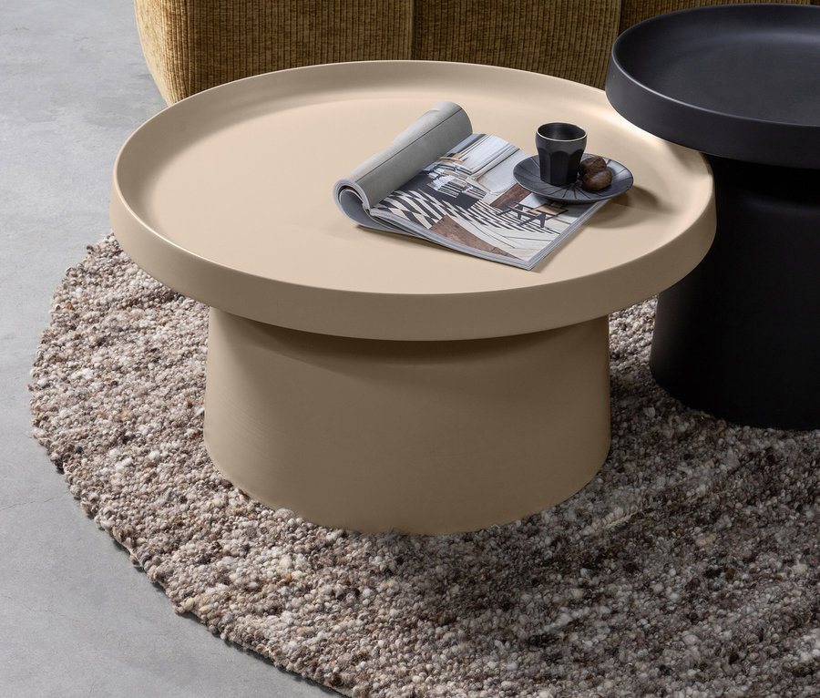 Beiger, runder Couchtisch mit aufgeschlagenem Magazin und Tasse auf einem zotteligen Teppich. Woood Teppich »Efia«, Ø 200 cm.