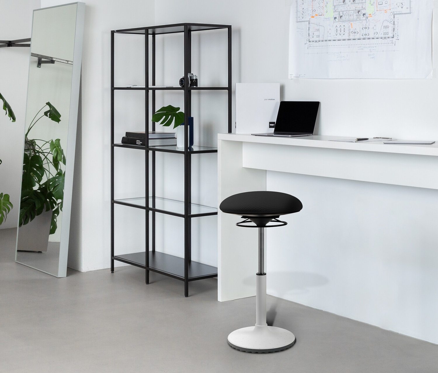 Weißer Innenraum mit schwarzem Topstar Hocker »BBT-Coach«, Regal, Spiegel und Tisch mit Laptop.