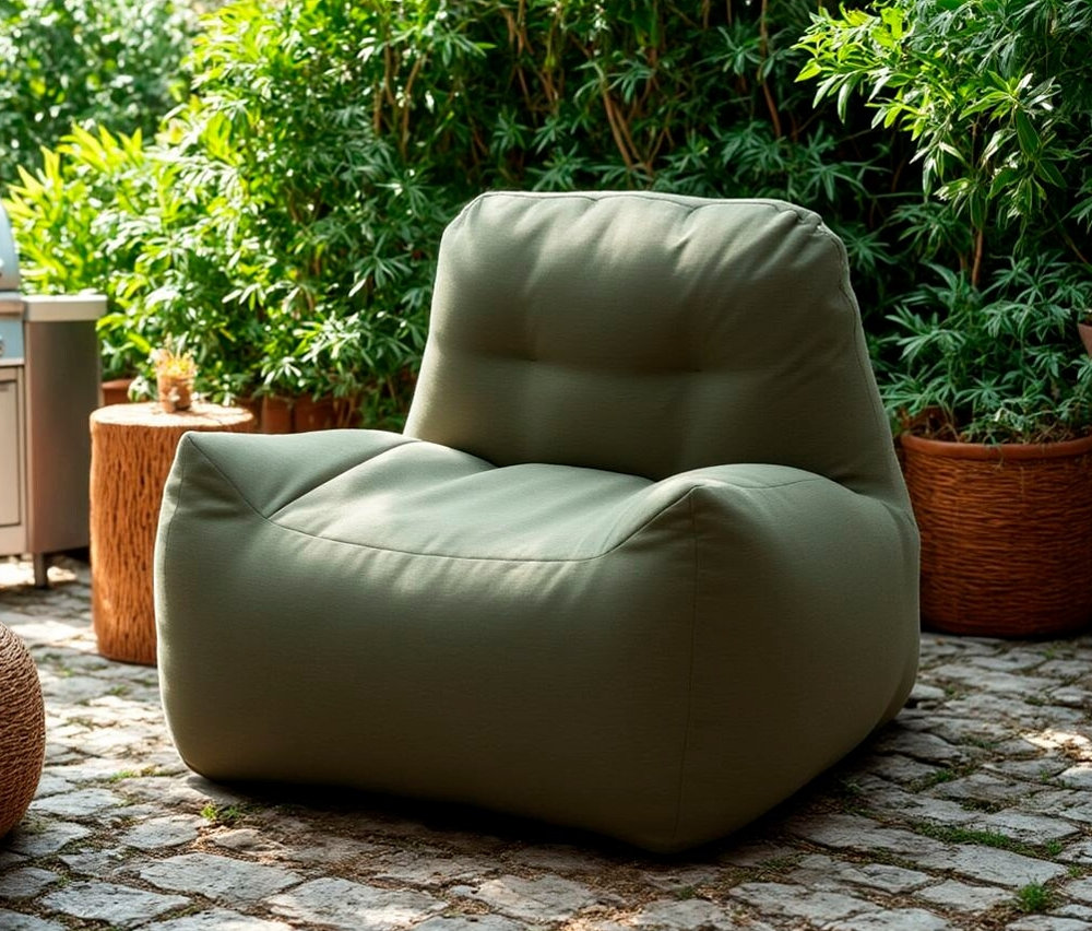 Ein grüner DOMO collection Loungesessel mit Sunbrella®-Stoff, Bamboo steht draußen auf einem Steinboden.