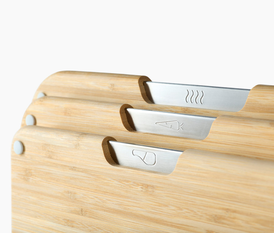Nahaufnahme von drei Bambus-Schneidebrettern mit silbernen Symbolen für verschiedene Lebensmittel.