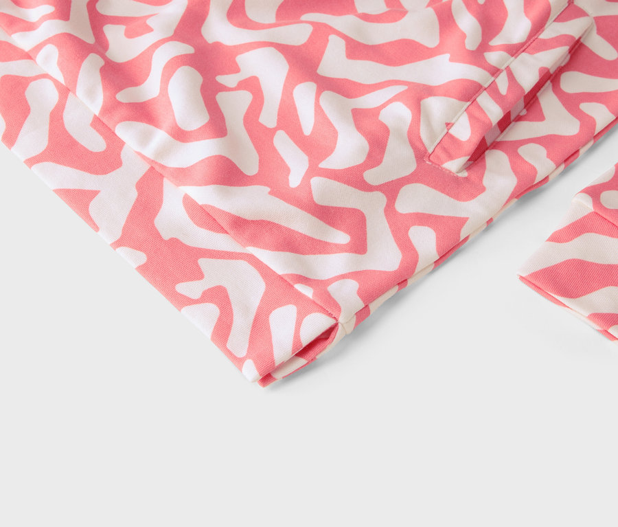 Nahaufnahme eines Kleidungsstücks mit rosafarbenem und weißem abstraktem Muster.