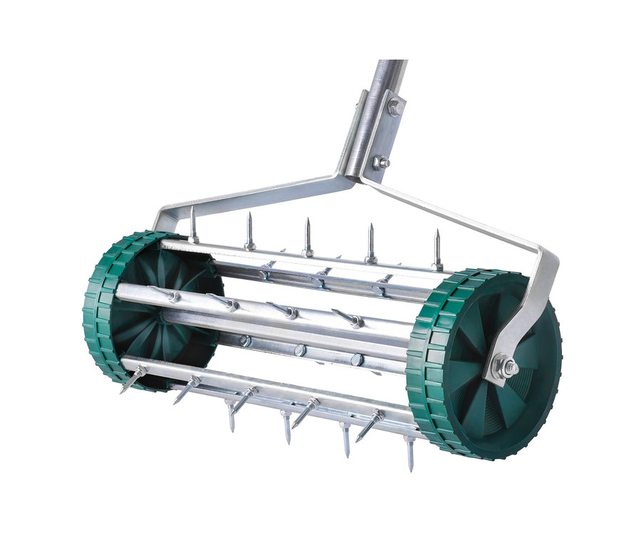 Detailaufnahme eines rollenden Rasenlüfters mit Stahlspikes und grünen Rädern.