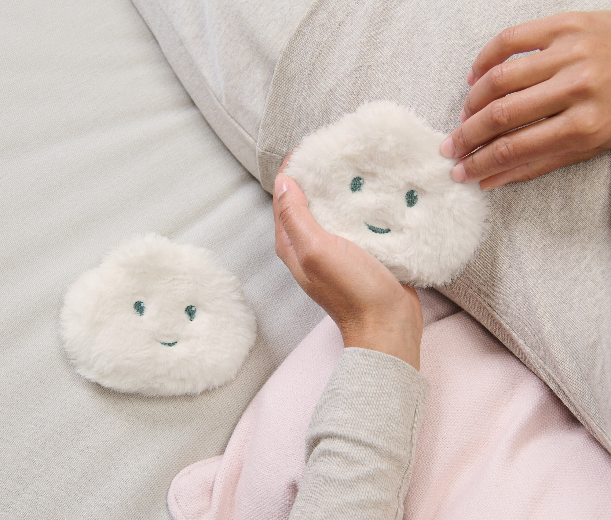Frau hält eines der 2 Taschenheizkissen in der Hand.