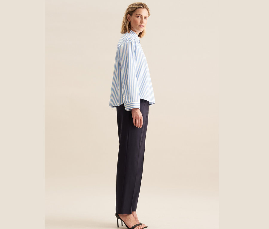 Frau posiert in Seidensticker Oversize Hemdbluse, blau und dunkelblauer Hose.