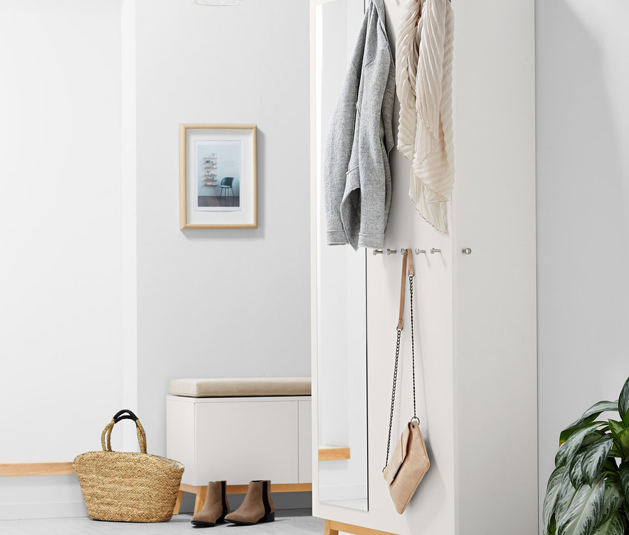 Innenaufnahme eines Flurschranks. An der Wand hängen eine Jacke und ein Schal.