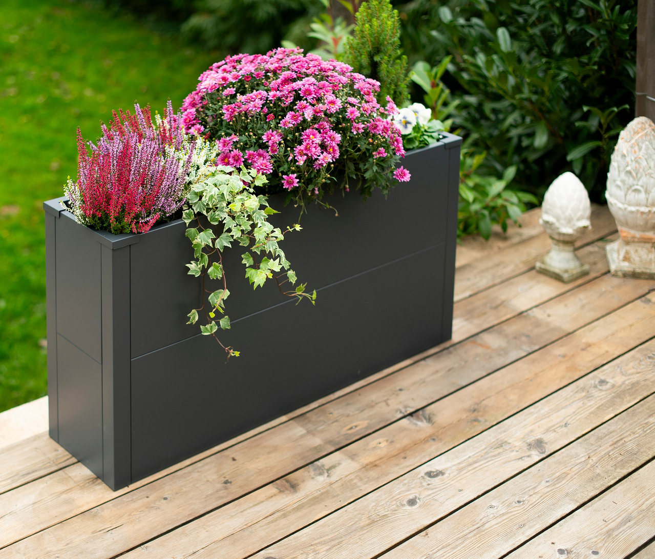 Verschiedene Blumen in anthrazitfarbenem Pflanzkasten mit Einlegeboden, Höhe ca. 52cm, auf einer Holzterrasse.