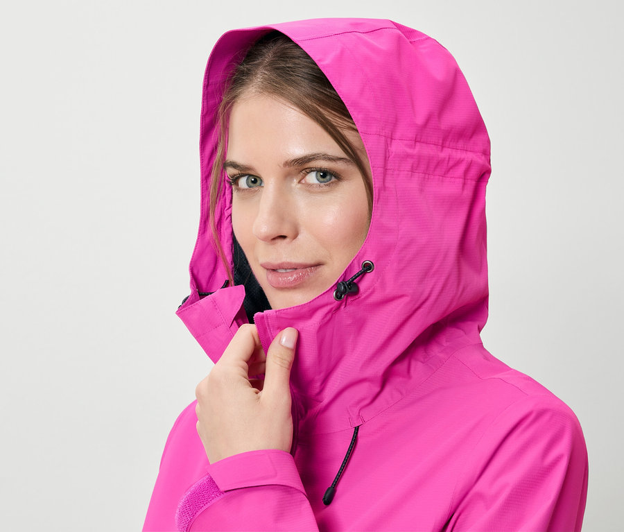 Frau schliesst pinke Regenjacke.