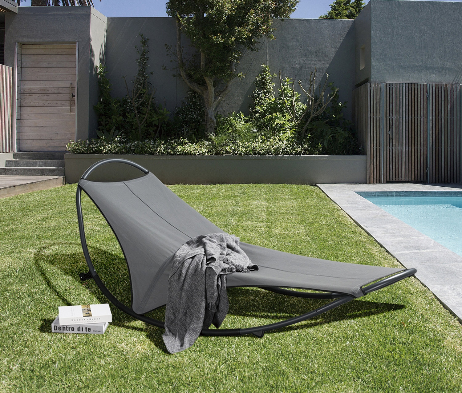 Graue Leco Schaukelliege auf Rasen am Pool.