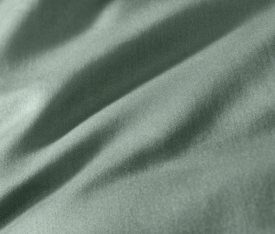 Nahaufnahme von grüner Baumwollsatin-Bettwäsche.