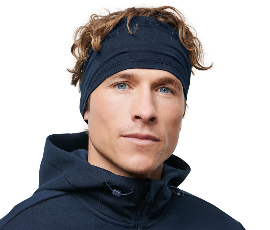 Mann mit braunen Haaren und blauen Augen trägt ein Sport-Stirnband.