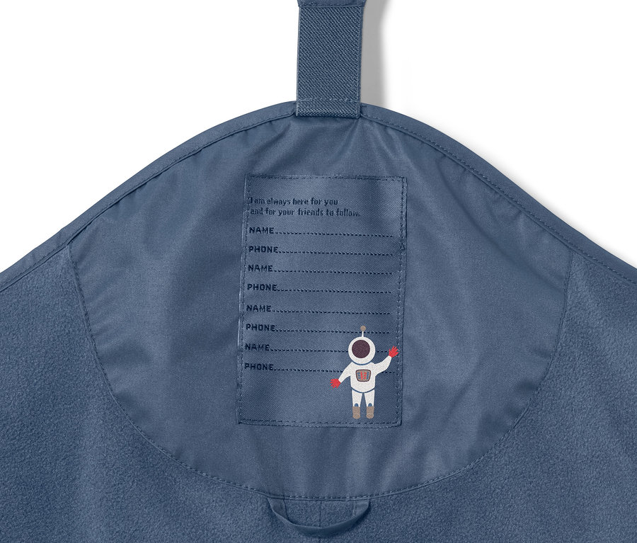 Detailaufnahme einer dunkelblauen Kinder-Thermo-Regenhose mit Astronautenprint und Platz für Name und Telefonnummer.