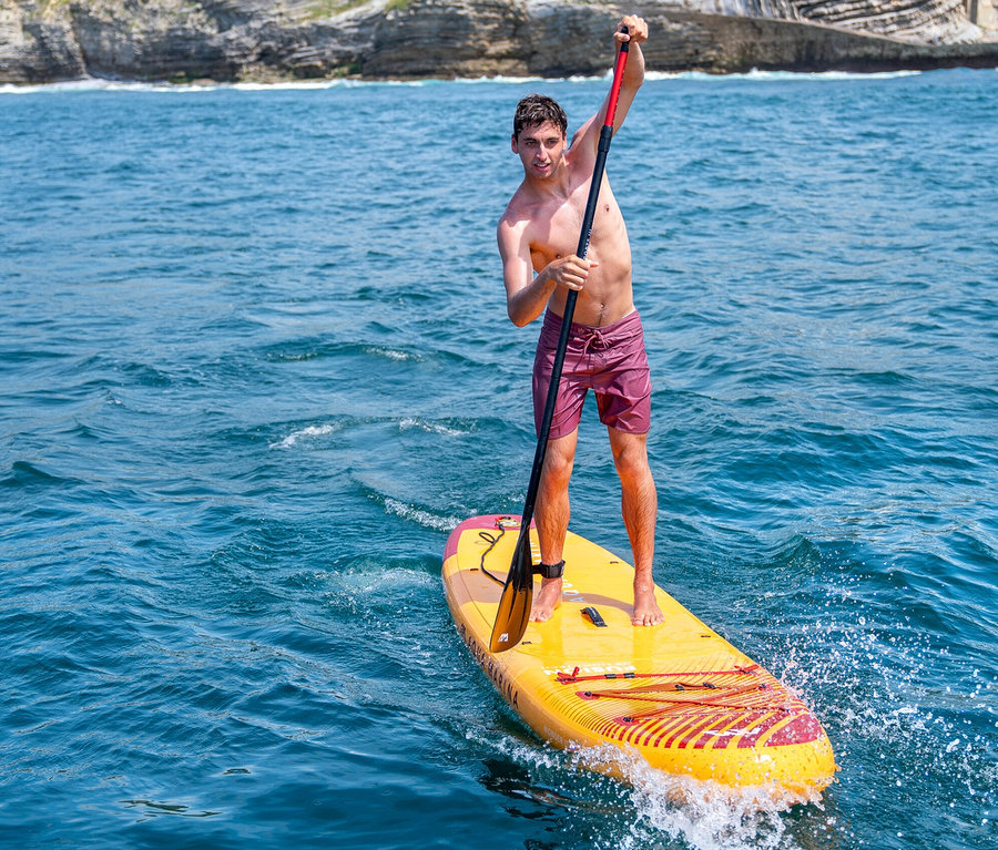 Mann paddelt stehend auf gelbem Aqua Marina SUP Board »Fusion« 10'10".