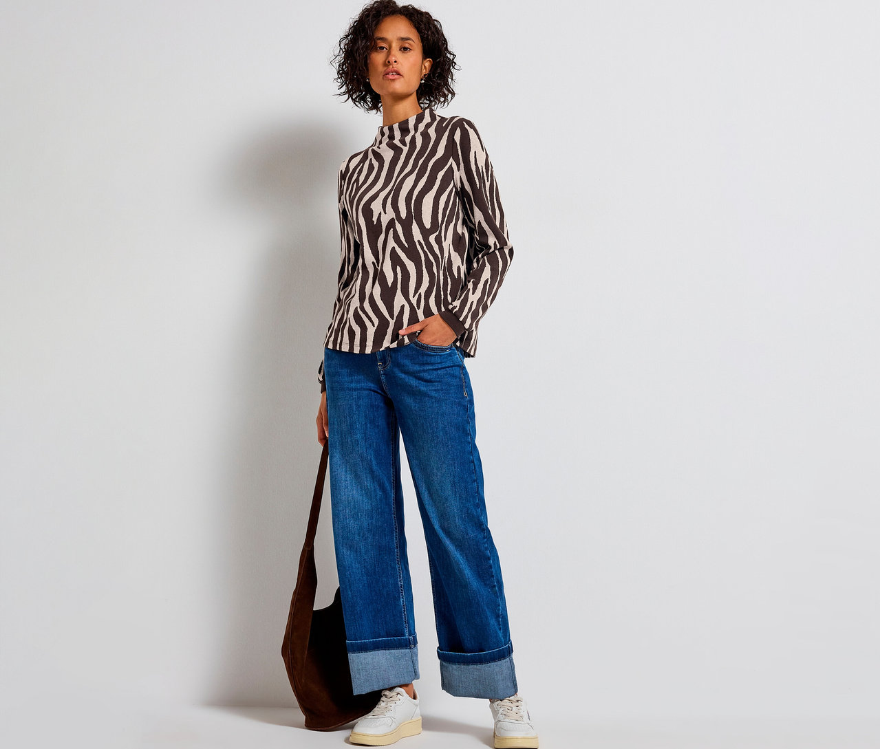 Frau mit Street One Jacquard-Shirt mit Zebramuster, Jeans und Tasche.