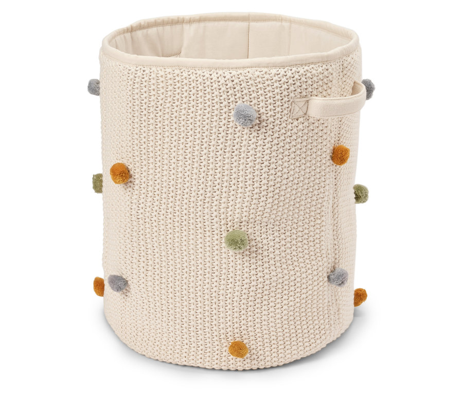 Beiger, runder Strickkorb mit bunten Bommeln und zwei Tragegriffen.