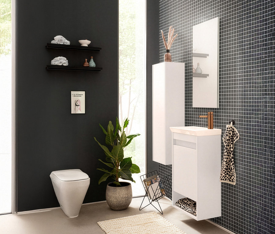 Badezimmer mit Toilette, Waschtisch, Spiegel und Regalen an einer dunklen Wand.