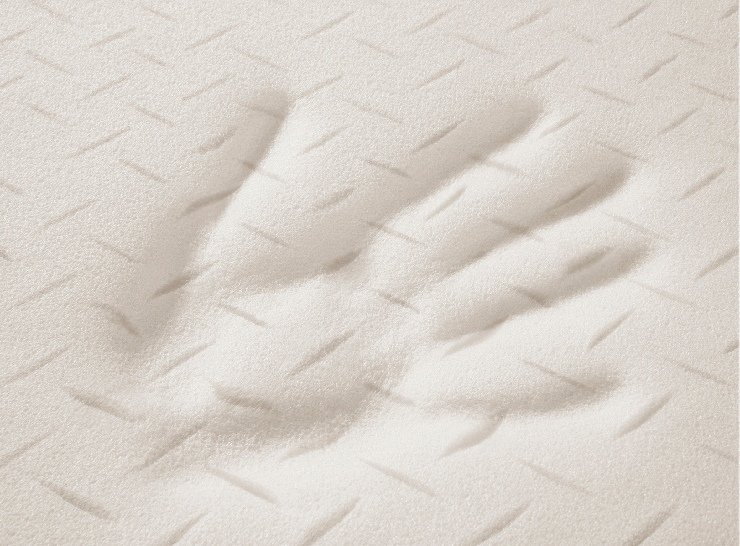 Handabdruck auf einem weißen irisette® Viscoschaum Matratzentopper.