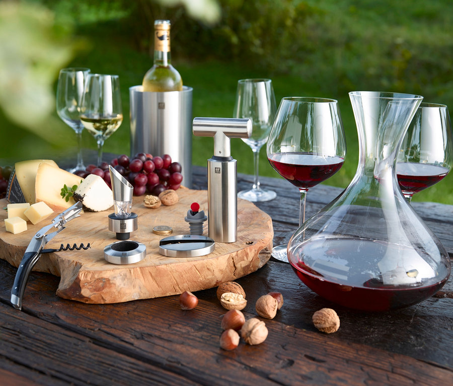 Auf einem Holztisch stehen ein ZWILLING Sommelier-Set, 4-teilig, Käse, Trauben und Weingläser.