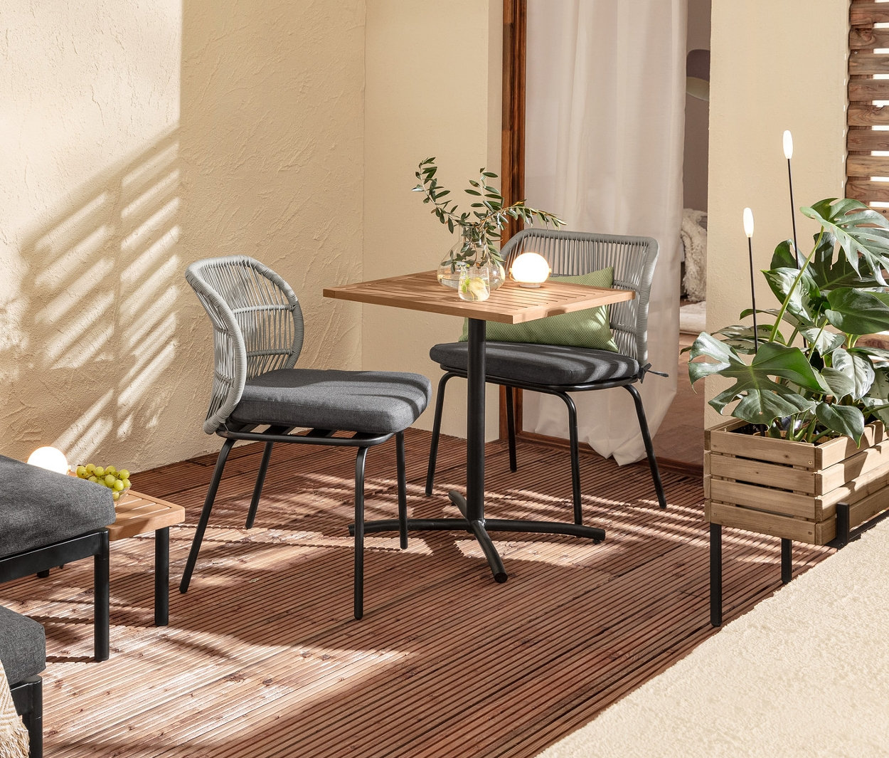 Einrichtung eines Balkons mit flexiblem Balkon-Lounge-Set »Elin«, Balkontisch, Stühlen mit Textilgeflecht, 2 Outdoor-Kissen, Pflanzkasten und 2 Solar-Leuchtstäben.
