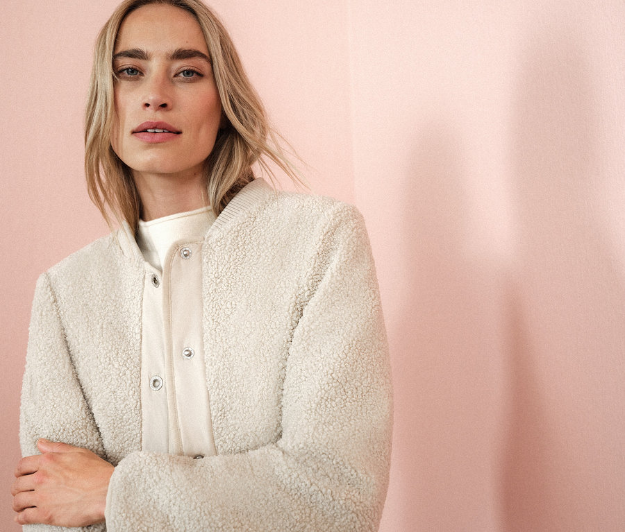 Frau trägt eine cremefarbene Jacke.