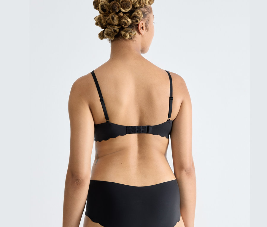 Rückenansicht einer Frau mit schwarzem sloggi ZERO Microfibre 2.0 Soft BH.