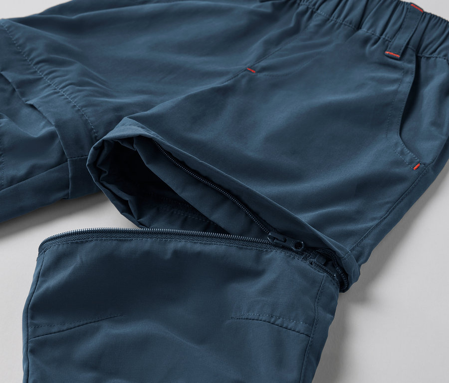 Detailaufnahme einer blauen Kleinkinder-Funktionshose mit Reißverschluss am Knie.