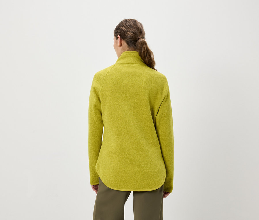 Rückansicht einer Frau mit Pferdeschwanz, die einen gelbgrünen Fleecepullover und olivgrüne Hosen trägt.