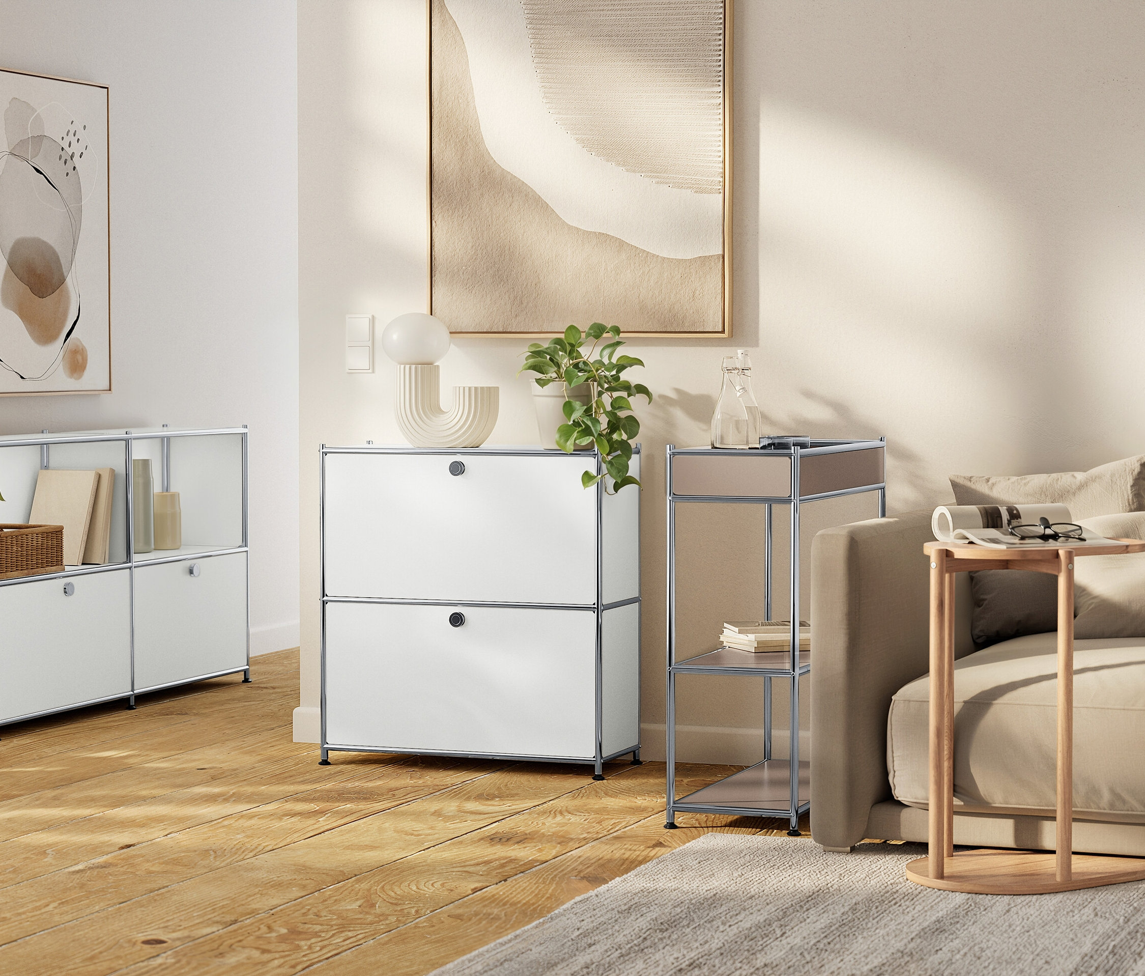 Ein Wohnzimmer mit weißen modularen Aufbewahrungseinheiten, einem beigen Sofa und neutralen Kunstwerken.