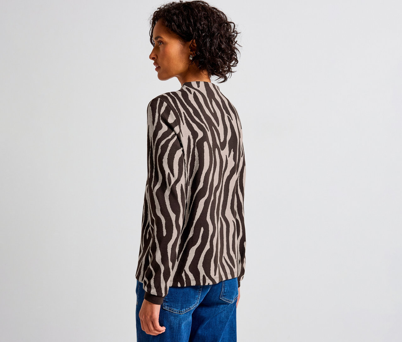 Frau trägt ein Street One Jacquard-Shirt mit Zebra-Muster und blaue Jeans.