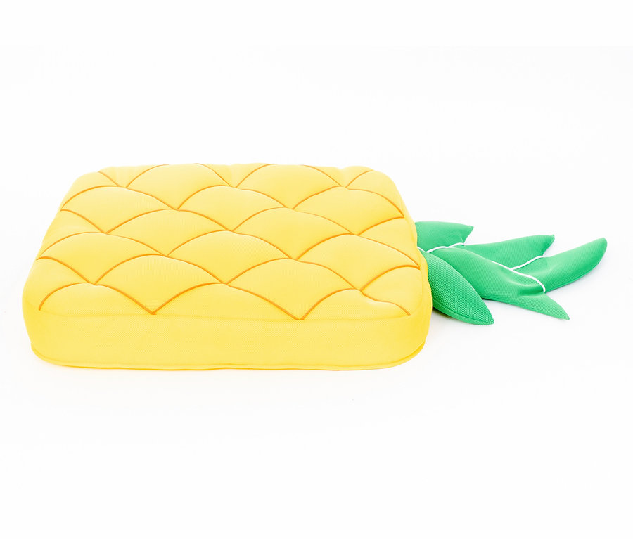 Ein gelbes Pool Buddy Ananas-Kissen mit Blättern auf einem weißen Hintergrund.