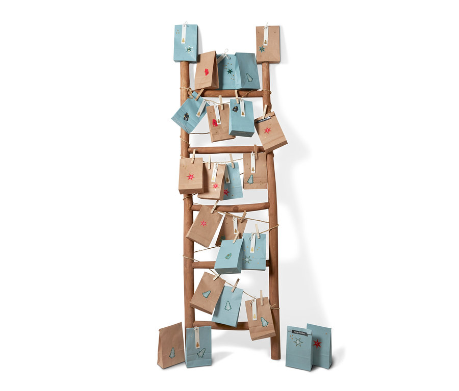 Adventskalender-und-Geschenktüten-Set hängen an einer Holzleiter.