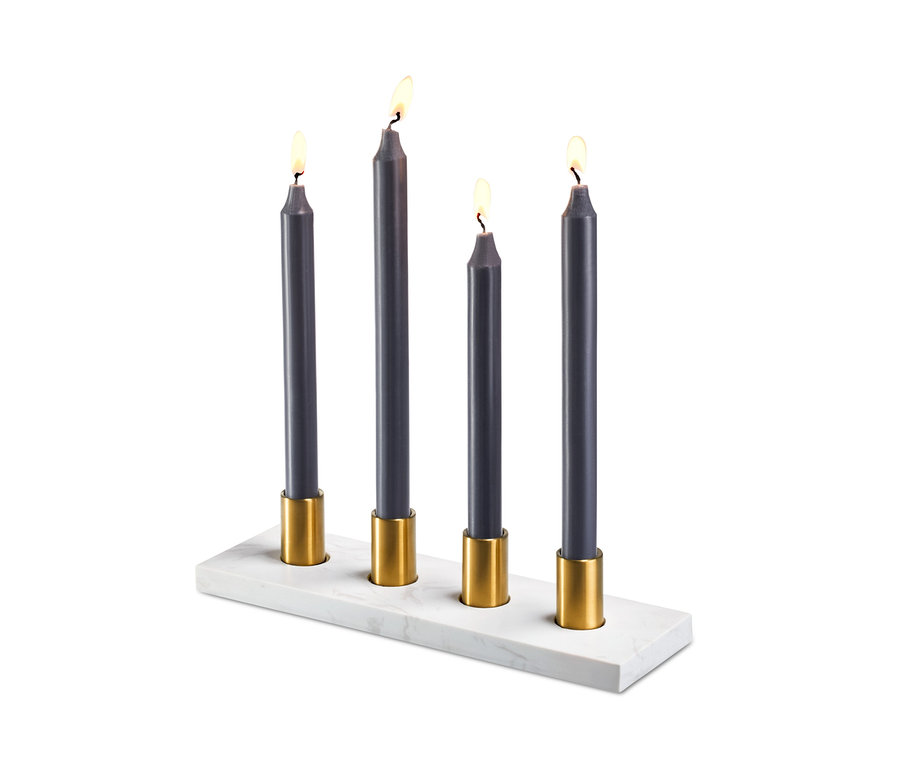 Vier brennende graue Kerzen in goldenen Haltern auf einem Marmor-Kerzenhalter.