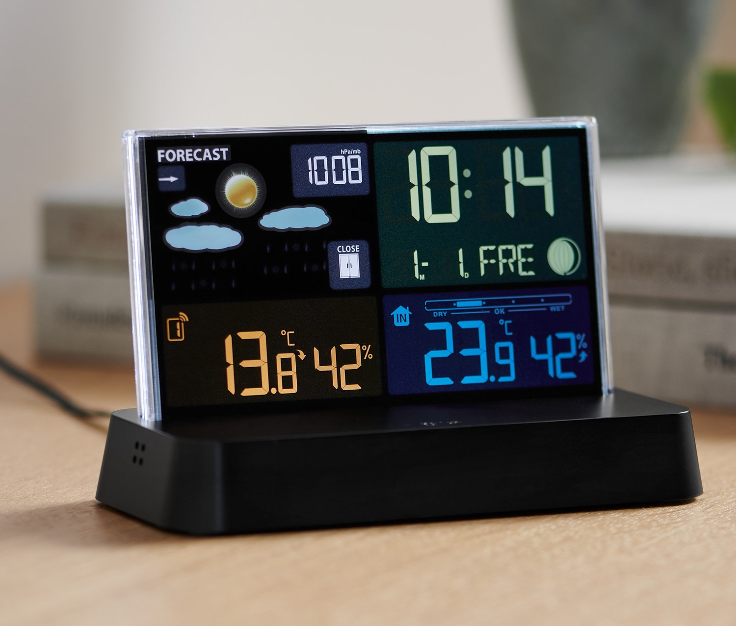 Eine schwarze Funk-Wetterstation mit LCD-Farbdisplay zeigt die Zeit 10:14, Temperaturen von 13,8 °C und 23,9 °C sowie eine Wettervorhersage.