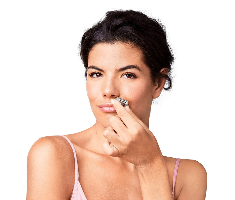 Frau verwendet Mini-Gesichtsepilierer.