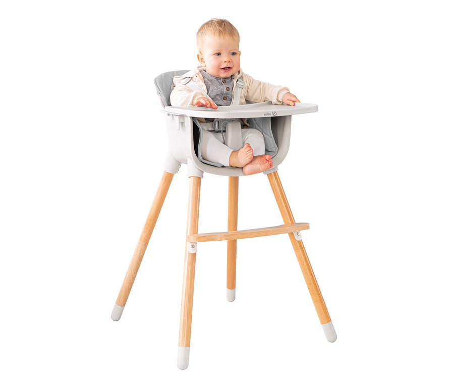 Ein Baby sitzt in einem grauen roba 2-in-1-Hochstuhl »Style Up wood« mit Holzbeinen.