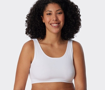 Frau trägt ein weißes SCHIESSER Bustier mit Bio-Baumwolle aus einem 2er Set und eine weiße Unterhose.