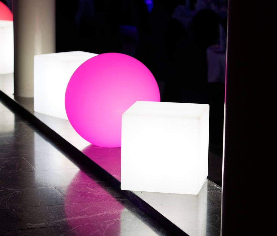 Zwei 8 seasons design LED-Leuchtwürfel, 43 cm, und eine pinke Kugel liegen auf dem Boden.