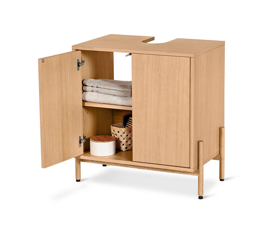 Offener Waschbeckenunterschrank mit Holzfurnier, innen Handtücher und ein Weidenkorb.