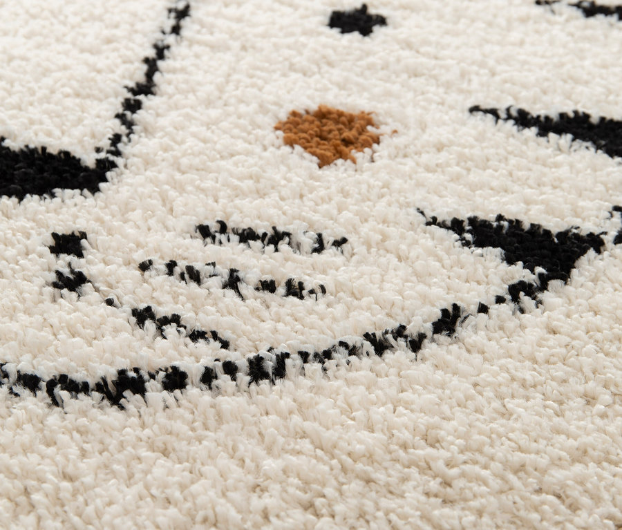 Detailansicht des Kinderteppichs NOMAD Tiger, Ø ca. 135 cm, mit einem Tigerdesign in Schwarz und Braun auf weißem Grund.