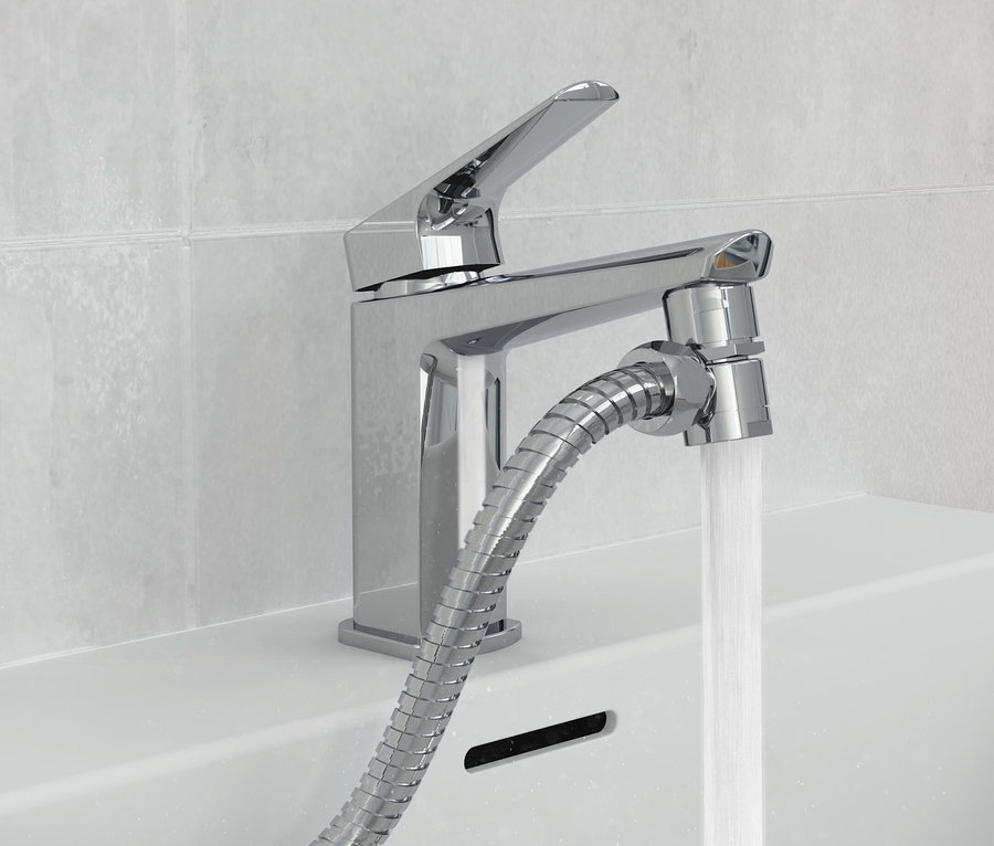 Wasser fließt aus einem Chromwasserhahn mit Schlauch in ein weißes Waschbecken.